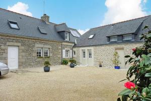 an old stone house with potted plants in a courtyard at Semi-detached house, Lesconil in Plobannalec-Lesconil