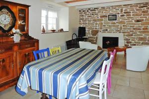 a dining room with a table and chairs and a fireplace at Semi-detached house, Lesconil in Plobannalec-Lesconil