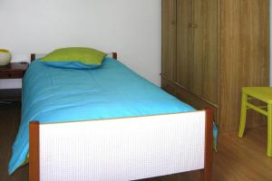 a bedroom with a bed with a blue blanket and a table at Semi-detached house, Lesconil in Plobannalec-Lesconil