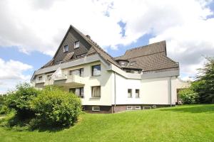 a large white house with a gambrel roof at Apartment, Hahnenklee in Hahnenklee-Bockswiese