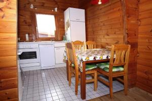 La cuisine est équipée d'une table, de chaises et d'un réfrigérateur. dans l'établissement Blockhouse, Hasselfelde, à Hasselfelde