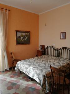 a bedroom with a bed and two chairs and a window at Bed and Breakfast Family Palazzo Stillitano Stilo in Stilo