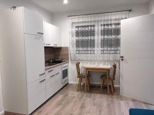 uma cozinha com armários brancos e uma mesa com cadeiras em FERIENWOHNUNG BAD DRIBURG em Bad Driburg