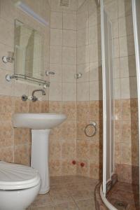 a bathroom with a toilet and a sink and a shower at Hotel Wesso in Kavarna