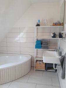 a bathroom with a tub and a sink at "Libelle am Bernsteinsee" in Stüde, Sassenburg in Sassenburg