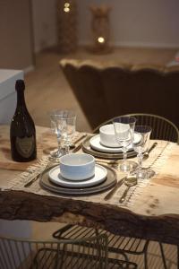 una mesa de madera con platos y copas de vino. en Casa Honey en Lieja