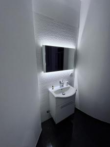 bagno bianco con lavandino e specchio di Dimora al Centro Home a Cosenza