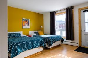 a bedroom with two beds and a window at Auberge de Jeunesse Le Camp De Base in LʼAnse-Saint-Jean