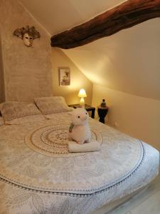 a teddy bear sitting on a bed in a bedroom at Jacuzzi Massage sur rdv,Duo,reiki,californien, réflexologie plantaire, et bouteille mousseux offerte in Férolles