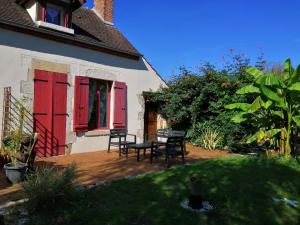 a patio with red doors and a table and chairs at Jacuzzi Massage sur rdv,Duo,reiki,californien, réflexologie plantaire, et bouteille mousseux offerte in Férolles