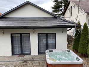 a hot tub in front of a house at Malibu Apartman & Jacuzzi in Miskolctapolca