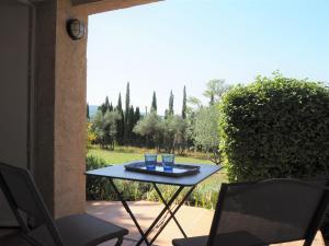 a table and chairs on a patio with a view of a yard at Cottage in Luberon near Apt Market in Apt