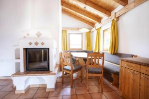 a living room with a fireplace and a table and chairs at Chalet, Hochkrimml in Krimml