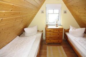 two beds in a attic bedroom with a window at Doppelhaushälften in Strandnähe in Boltenhagen in Boltenhagen