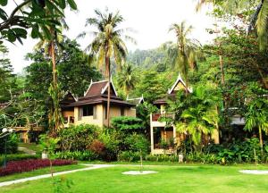 a house in the middle of a yard with palm trees at Bhumiyama Plus in Ko Chang