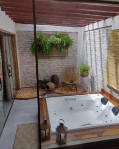 a large bath tub in a room with plants at Pousada Santa Vila in Serra do Cipo