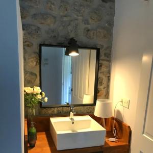 y baño con lavabo blanco y espejo. en casaplayadevega, en La Vega