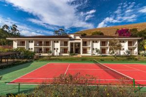 a tennis court in front of a building at Resort Fazenda 3 Pinheiros in Engenheiro Passos