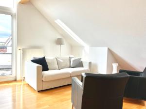 a living room with a white couch and a window at Apartment mit Dachterrasse & Sauna in Wangen im Allgäu