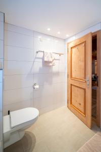 a bathroom with a toilet and a wooden door at Haus Buachwald in Schruns