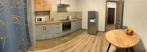 a kitchen with a table and a refrigerator at ШИКАРНАЯ СОЛНЕЧНАЯ однокомнатная квартира in Khmelʼnytsʼkyy +4 photos