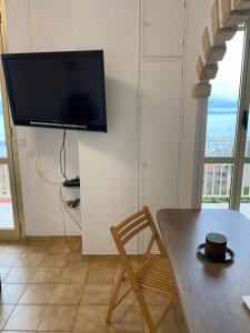uma sala de estar com uma mesa e uma televisão na parede em Charmant deux pièces aux portes de Monaco em Cap d'Ail