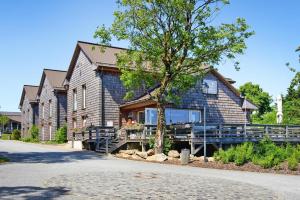 ein Holzhaus mit einem Baum davor in der Unterkunft Semi-detached houses, turf house in Torfhaus