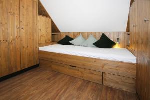 een slaapkamer met een bed in een houten hut bij Semi-detached houses, turf house in Torfhaus