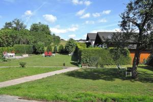 a garden with tables and chairs in the grass at Apartment in Lissendorf with a paid private sauna in Lissendorf