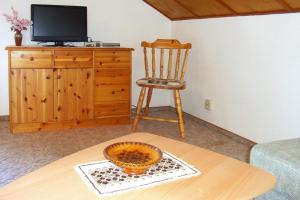 a room with a table and a chair and a television at Vacation Home, Oberschoenau in Oberschönau