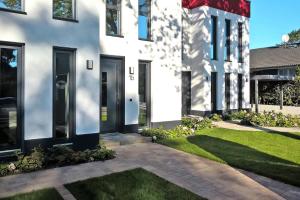 a white house with black doors and a yard at Semi-detached houses, Strausberg in Strausberg