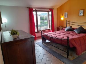 1 dormitorio con 1 cama con edredón rojo y ventana en LA TERRAZZA DI OTTO, en Orvieto