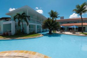 a large swimming pool in front of a hotel at Baía Branca Beach Resort in Tamandaré