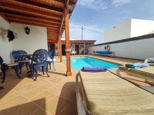 a patio with a pool and chairs and a table at VolKKanrentals Villa Baljat in El Mojón