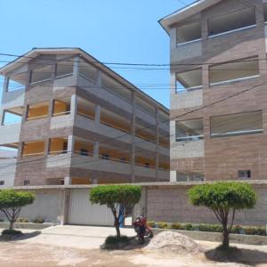 um edifício com uma moto estacionada em frente em Condomínio manguezal em Porto de Galinhas