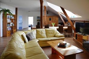 ein Wohnzimmer mit einem gelben Sofa und einem TV in der Unterkunft Apartment, Burow in Gischow