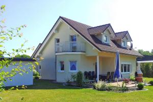 Casa con balcón y sombrilla azul en Ferienhaus Möwe in Mirow, en Mirow