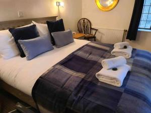 a bedroom with a bed with towels on it at Round Lodge Dorset in Sherborne