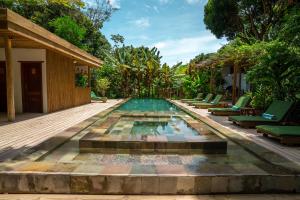 托兰克索DA GRAÇA HOTEL的一个带躺椅和房屋的无边泳池