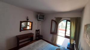 a bedroom with a bed and a mirror and a window at Departamentos Carlos Paz bajada al lago in Villa Carlos Paz