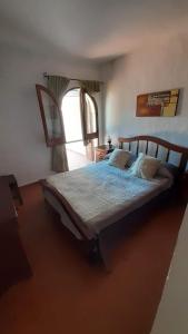 a bedroom with a large bed with a large window at Departamentos Carlos Paz bajada al lago in Villa Carlos Paz +113 photos