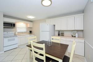 a kitchen with a wooden table and white cabinets at Canal 313 - Right in Siesta Key Village! in Siesta Key