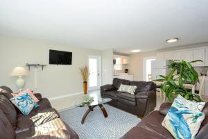 a living room with two couches and a table at Canal 313 - Right in Siesta Key Village! in Siesta Key