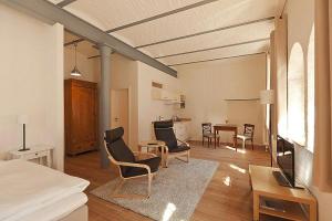 a living room with chairs and a dining room at Apartments in the Sudhaus, Schwerin in Schwerin