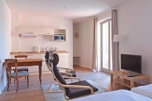 a living room with a table and chairs and a kitchen at Apartments in the Sudhaus, Schwerin in Schwerin