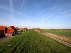 a field of green grass with houses in the background at Apartment in Neßmersiel mit Terrasse in Neßmersiel +8 photos