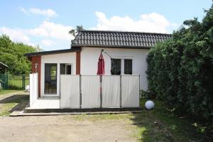 SommersdorfにあるApartment on Lake Kummerow, Sommersdorfの白柵と赤傘の家