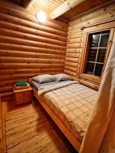 ein Schlafzimmer mit einem Bett in einem Blockhaus in der Unterkunft Kelgumäe in Otepää