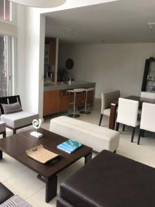 ein Wohnzimmer mit einer Couch und einem Tisch und Stühlen in der Unterkunft Dpto unico en un lugar magico en Pinamar ,Terrazas al Golf!! in Pinamar