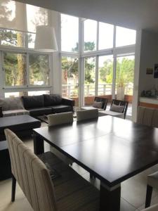 ein Wohnzimmer mit Tisch und Couch in der Unterkunft Dpto unico en un lugar magico en Pinamar ,Terrazas al Golf!! in Pinamar